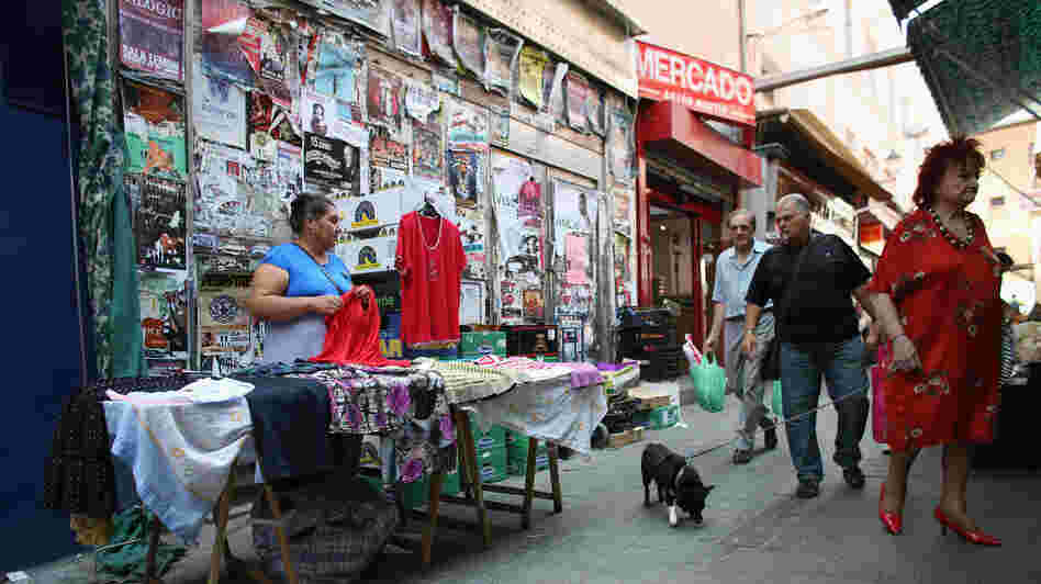Unemployment is rampant in Spain and full-time jobs are scarce. Here a woman works at a street stall in Madrid. Some Spaniards are signing up for "time banks," where individuals perform services based on their skills, and receive another service in return. No money changes hands. A woman is shown here working at a street stall in Madrid.
