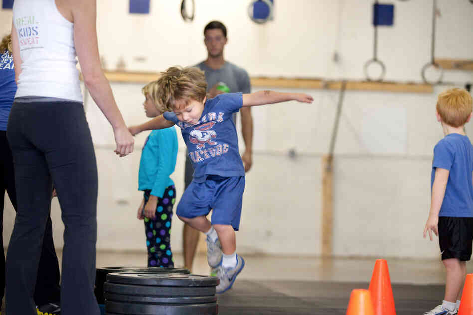 Evan Ciangiulli, 4, hops onto a stack of weights as part of his CrossFit training in Rockville, Md.