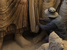 Above, an Afghan archaeologist drapes a fabric across the remains of Buddha statues discovered inside an ancient monastery in Mes Aynak on Nov. 23, 2010. Above, an Afghan archaeologist drapes a fabric across the remains of Buddha statues discovered inside an ancient monastery in Mes Aynak on Nov. 23, 2010.
