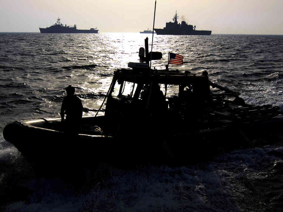 A U.S. Navy speedboat passes in front of multinational military ships in the Persian Gulf on Sept. 21 as part of the military exercise. If attacked, Iran says it will close the Strait of Hormuz, which is a crucial shipping route.