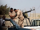 Soldiers from the Libyan National Army get ready to enter the compound of Rafallah al-Sahati in Benghazi on Saturday. Libya's president announced that all government-aligned militias will now report to the army chief of staff, and that all other armed groups must disband. Soldiers from the Libyan National Army get ready to enter the compound of Rafallah al-Sahati in Benghazi on Saturday. Libya's president announced that all government-aligned militias will now report to the army chief of staff, and that all other armed groups must disband.