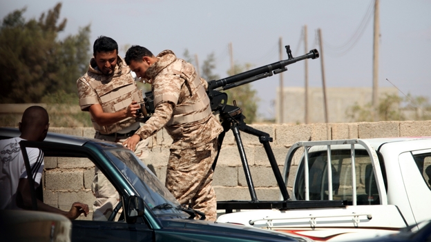 Soldiers from the Libyan National Army get ready to enter the compound of Rafallah al-Sahati in Benghazi on Saturday. Libya's president announced that all government-aligned militias will now report to the army chief of staff, and that all other armed groups must disband.