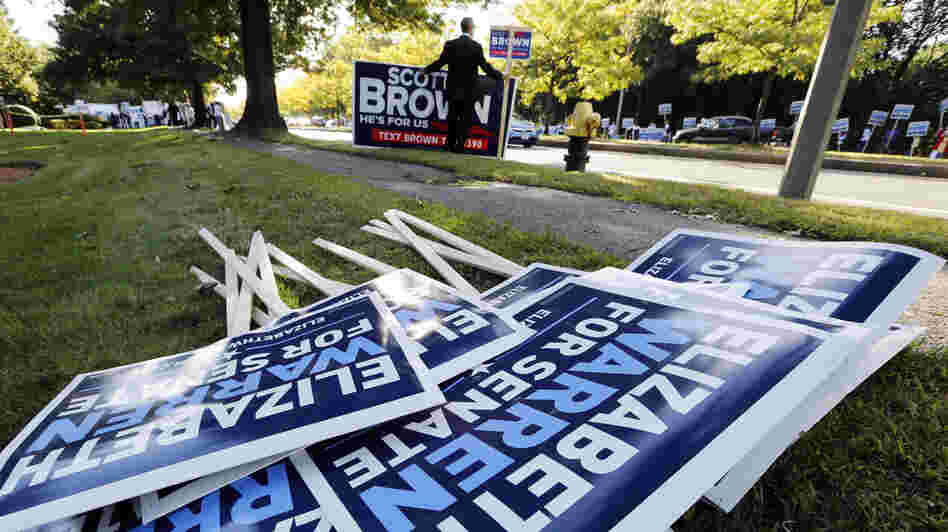 Bill Connell of Weymouth, Mass., who supports Republican Sen. Scott Brown, stands near signs supporting Brown's Democratic challenger, Elizabeth Warren, before the candidates' first debate Thursday in Boston.