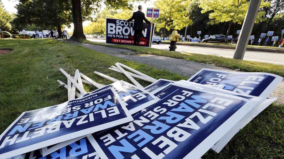 Bill Connell of Weymouth, Mass., who supports Republican Sen. Scott Brown, stands near signs supporting Brown's Democratic challenger, Elizabeth Warren, before the candidates' first debate Thursday in Boston.