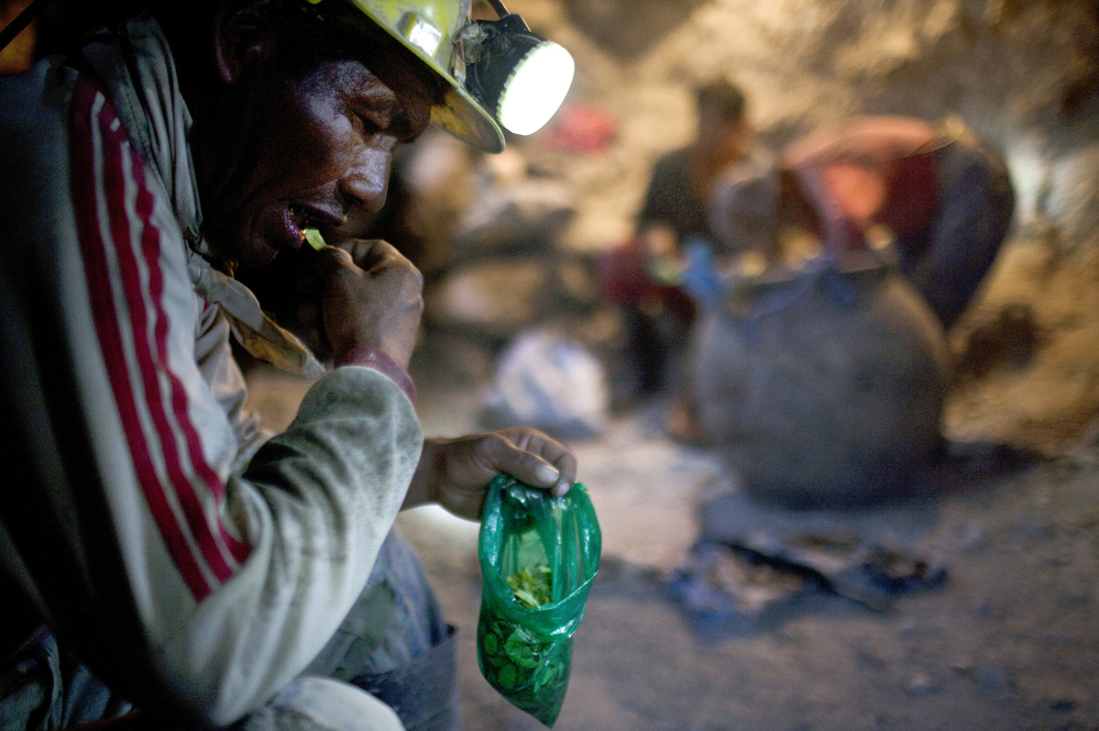 Elogio Tola, 45, a miner since he was a boy, takes a break with coca leaves, chewing bagfuls to ward off hunger and exhaustion in the Cerro Rico silver mines in Potosi last month.