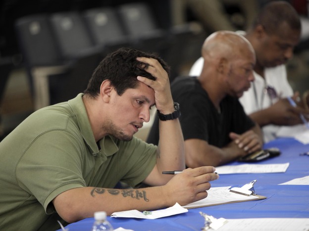 Job seekers fill out applications Aug. 21 at a construction job fair in New York. Polls show voters want the presidential candidates to provide more details on how they would reduce unemployment, change tax policy and alter government spending.