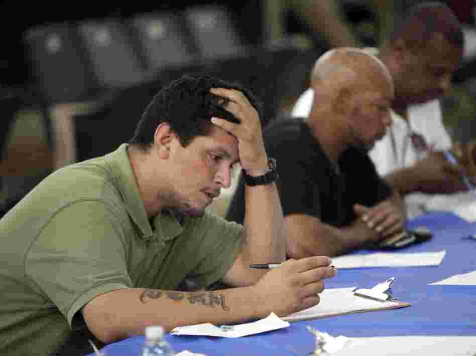 Job seekers fill out applications Aug. 21 at a construction job fair in New York. Polls show voters want the presidential candidates to provide more details on how they would reduce unemployment, change tax policy and alter government spending.