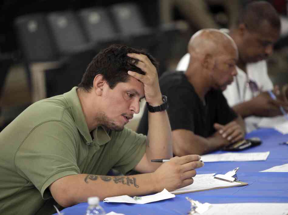 Job seekers fill out applications Aug. 21 at a construction job fair in New York. Polls show voters want the presidential candidates to provide more details on how they would reduce unemployment, change tax policy and alter government spending.