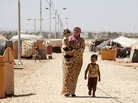 A Syrian refugee walks with her children at Zaatari refugee camp in Mafraq, Jordan, near the Syrian border, Sept. 8. Around 30,000 Syrians live at the camp, with the numbers growing each day. A Syrian refugee walks with her children at Zaatari refugee camp in Mafraq, Jordan, near the Syrian border, Sept. 8. Around 30,000 Syrians live at the camp, with the numbers growing each day.