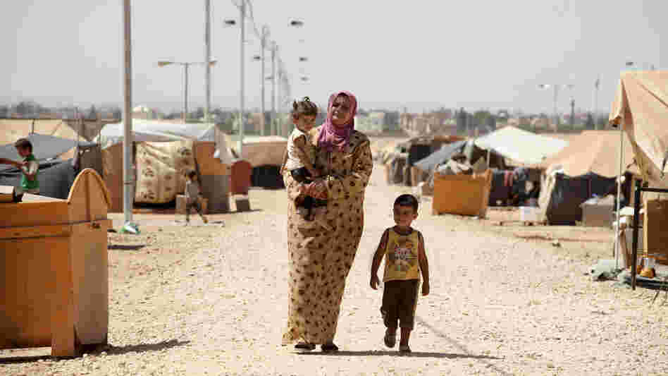 A Syrian refugee walks with her children at Zaatari refugee camp in Mafraq, Jordan, near the Syrian border, Sept. 8. Around 30,000 Syrians live at the camp, with the numbers growing each day.