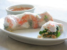 A Classic Summer Roll with shrimp on a plate, with a bowl of dipping sauce in the background A Classic Summer Roll with shrimp on a plate, with a bowl of dipping sauce in the background