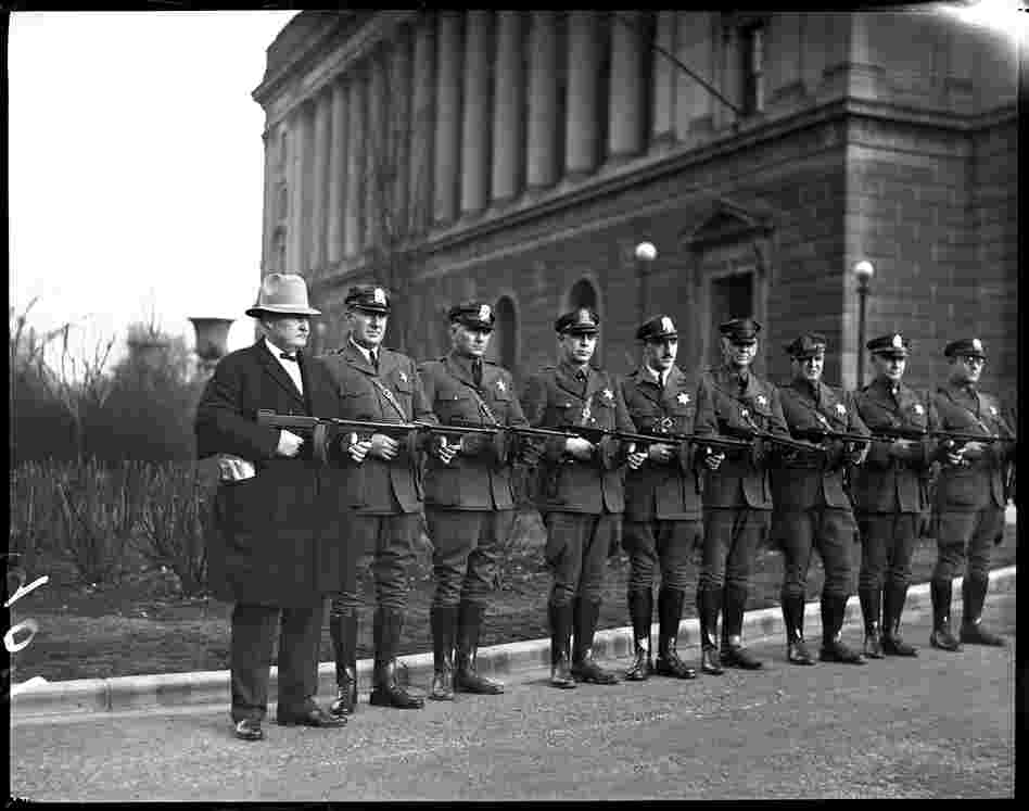 The Illinois State Police purchased new Thompson submachine guns in 1931 to help them face the threats of the day, which included bootleggers and labor unrest that frequently turned violent. The guns were issued to every sergeant in each police district throughout the state. Capt. Carr (left) posed with his officers and their guns in front of the Centennial Building, February 1931.