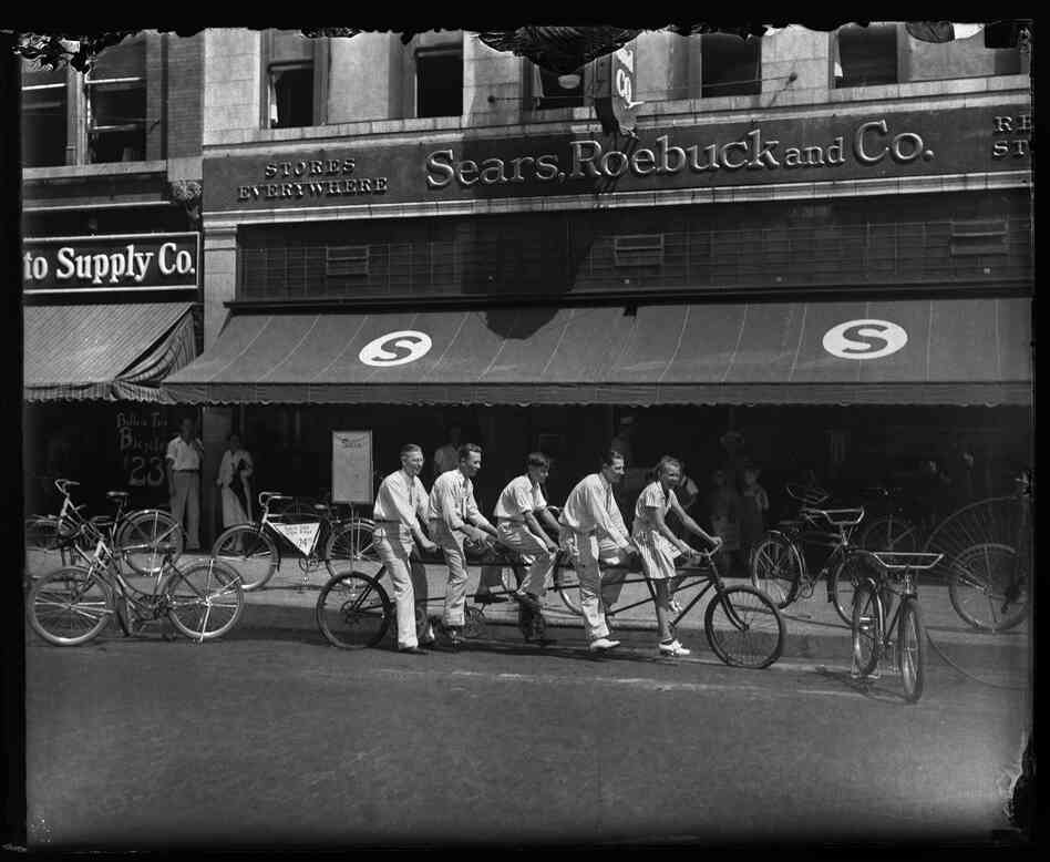 Five-person bicycle in front of Sears, Roebuck & Co., downtown Springfield, circa 1933.