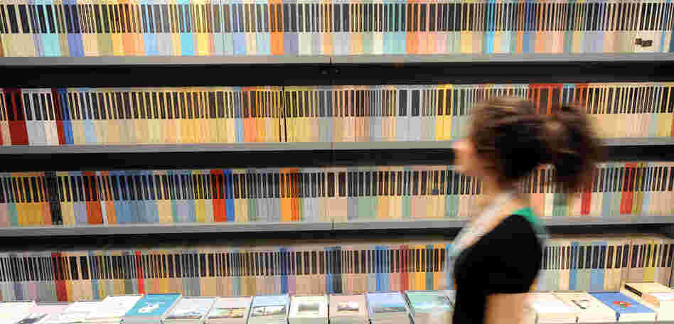 A woman walks in front of a bookshelf at Turin's book fair on May 08, 2008. A woman walks in front of a bookshelf at Turin's book fair on May 08, 2008.