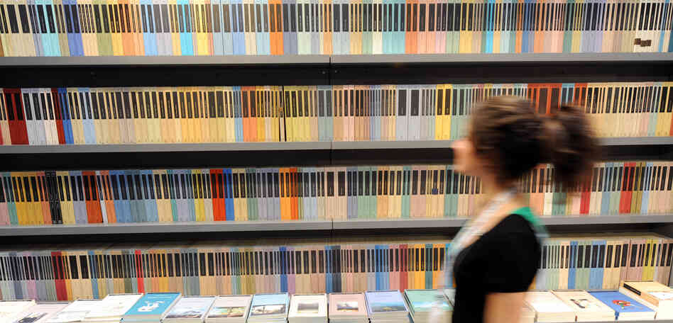 A woman walks in front of a bookshelf at Turin's book fair on May 08, 2008. A woman walks in front of a bookshelf at Turin's book fair on May 08, 2008.