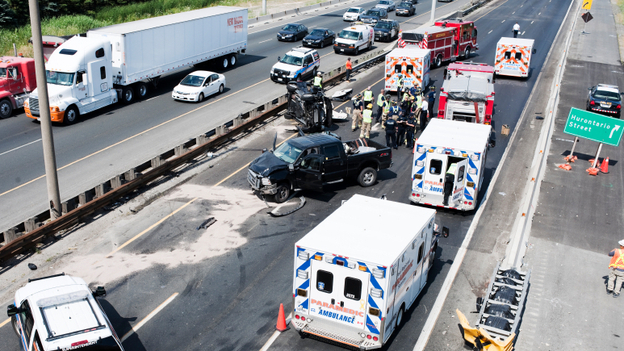 Fire department personnel, police officers and paramedics at the scene of a fatal collision on Highway 401 in Mississauga, Ontario, in July 2011.