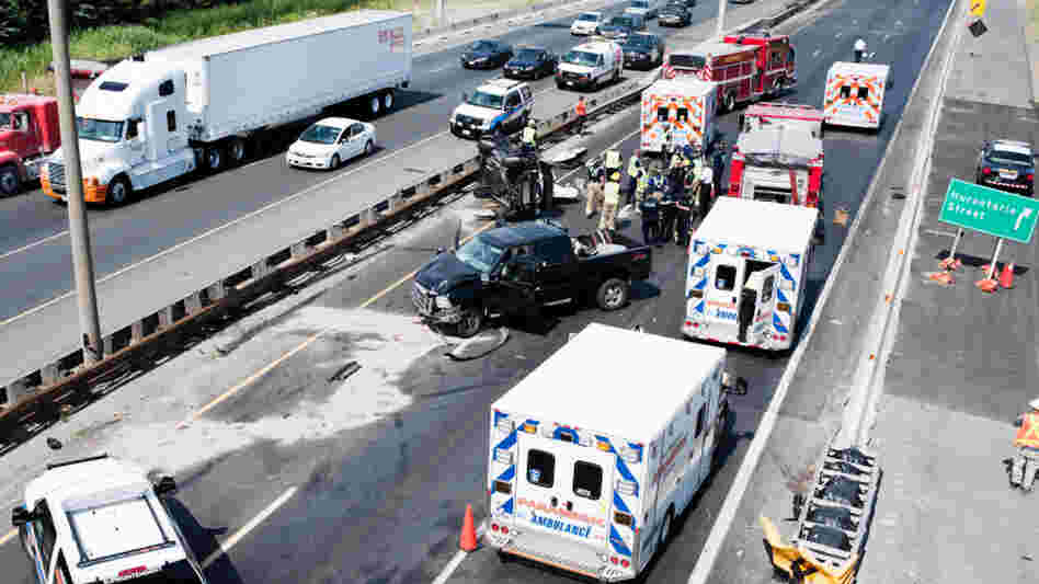 Fire department personnel, police officers and paramedics at the scene of a fatal collision on Highway 401 in Mississauga, Ontario, in July 2011.
