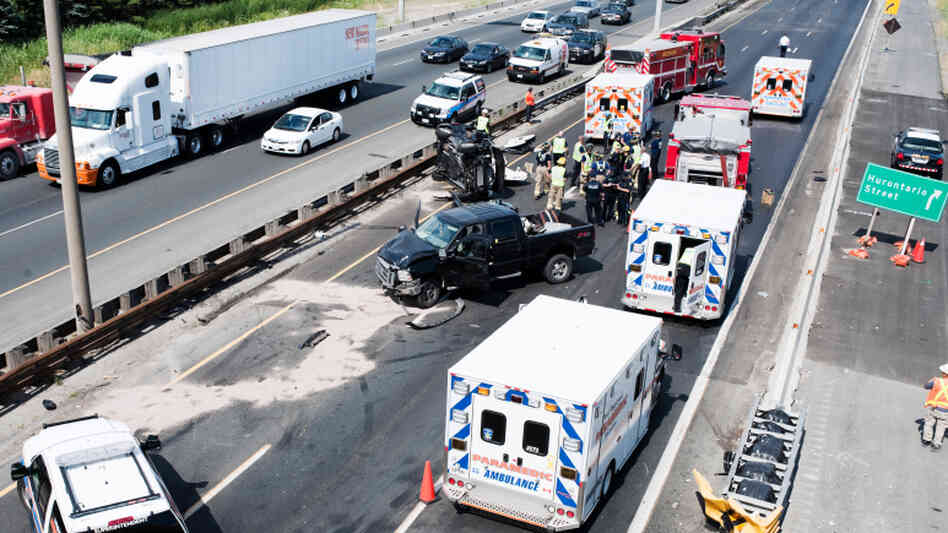 Fire department personnel, police officers and paramedics at the scene of a fatal collision on Highway 401 in Mississauga, Ontario, in July 2011.
