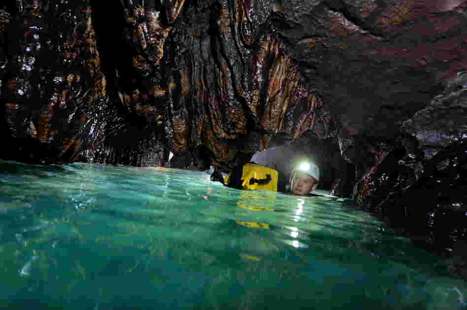 James Alker swims through the Pseudo Siphon at a depth of 1,118 meters (about 1,223 yards). With a water temperature of below 4 degrees Celsius (39.2 F), the long swim through the narrow canal chills the body through to the bone.