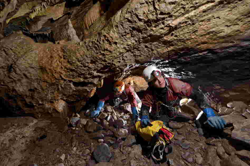 Cavers crawl through a 10-meter-long (about 33 feet) section of the cave.