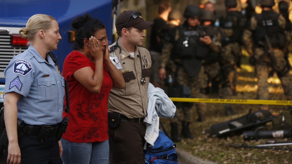 In shock: The scene outside a Minneapolis business Thursday. A gunman killed four people, wounded four others and then killed himself.