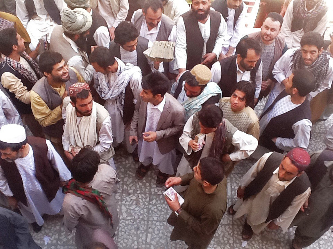 Money-changers in the Afghan city of Herat carry large stacks of Iranian currency.