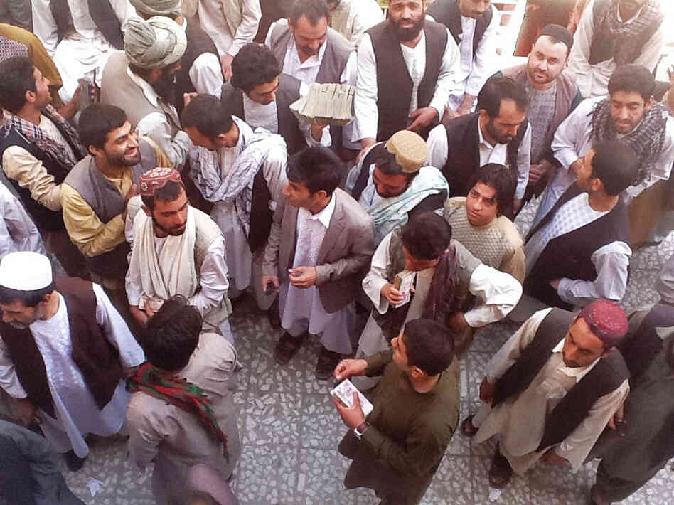 Money-changers in the Afghan city of Herat carry large stacks of Iranian currency.
