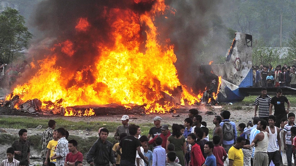 Plane wreckage burns near the airport in Katmandu, Nepal, following an accident that killed 19 people aboard.