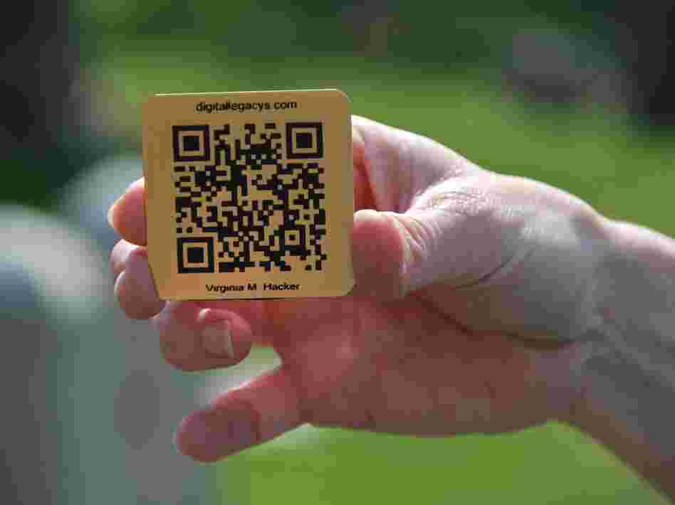 Lorie Miller holds the brass QR code for her grandmother's gravestone. Smartphone users who scan it will be directed to an online tribute.