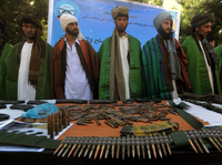 Former Taliban fighters display their weapons as they join Afghan government forces during a ceremony in Herat province on Sept. 18.
