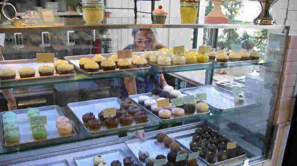 Nicole Kotovos arranges cupcakes in the case at her store in Athens.
