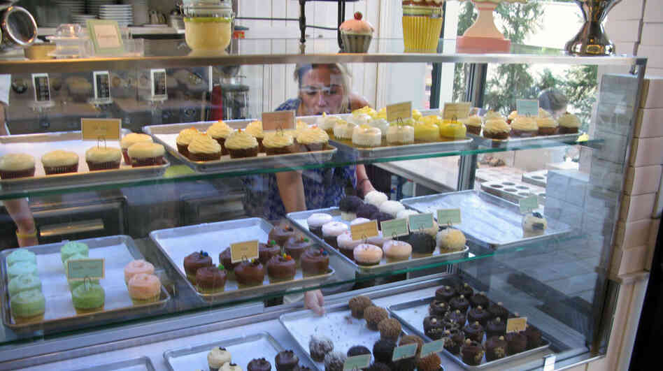 Nicole Kotovos arranges cupcakes in the case at her store in Athens.