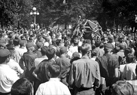 Hundreds of Ole Miss students crowd the street in front of the registrar's office, hoisting a Confederate flag and shouting for continued segregation.