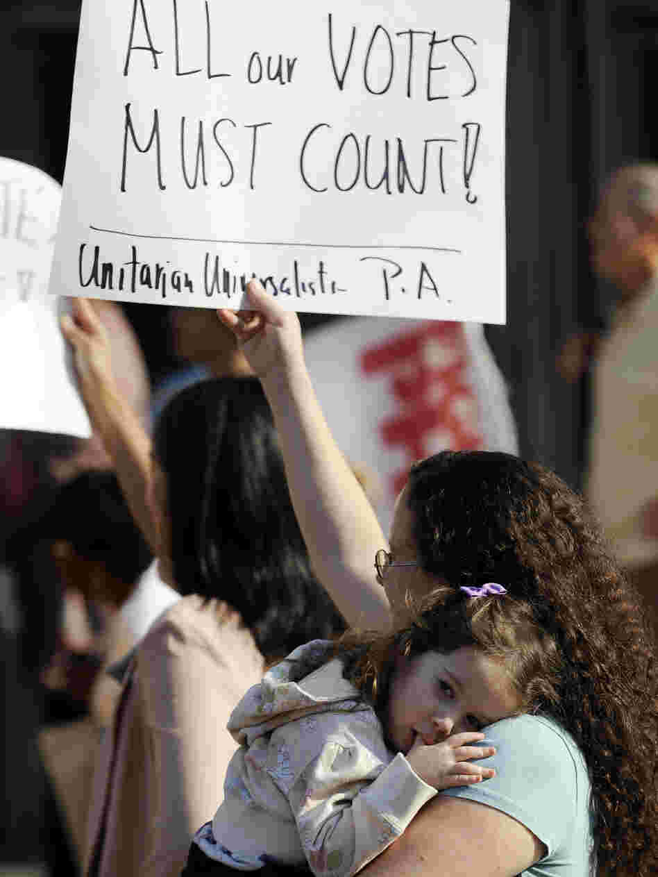 Emily Goldberg, with her daughter, Willa, 2, holds up a sign during the NAACP voter ID rally to protest against Pennsylvania's voter ID law on Sept. 13. Tuesday, a judge ordered that the law not be enforced in the Nov. 6 presidential election.