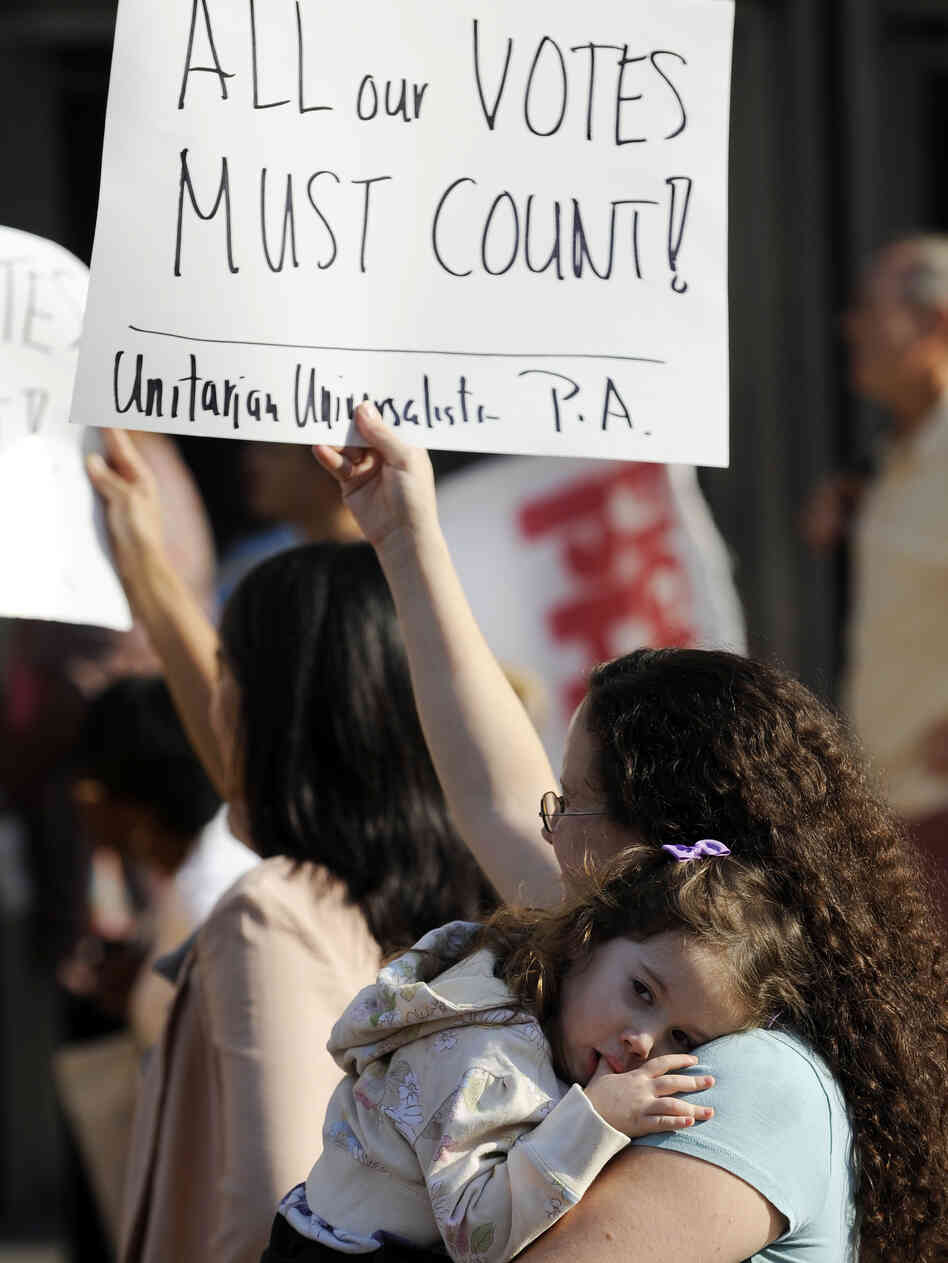 Emily Goldberg, with her daughter, Willa, 2, holds up a sign during the NAACP voter ID rally to protest against Pennsylvania's voter ID law on Sept. 13. Tuesday, a judge ordered that the law not be enforced in the Nov. 6 presidential election.