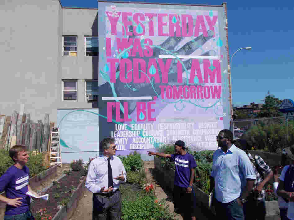 The Brownsville NeON probation office partnered with the public arts group Groundswell to establish a community garden in Brownsville. Local probationers designed and created the garden and mural. Here, the commissioner of the New York City Department of Probation, Vincent Schiraldi (second from left), meets with local advocates involved in the project. 