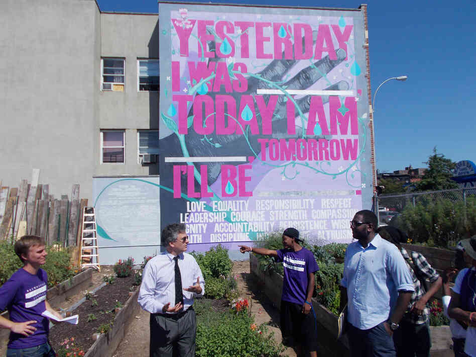 The Brownsville NeON probation office partnered with the public arts group Groundswell to establish a community garden in Brownsville. Local probationers designed and created the garden and mural. Here, the commissioner of the New York City Department of Probation, Vincent Schiraldi (second from left), meets with local advocates involved in the project. 