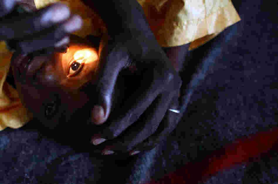 A health worker looks for signs of vision in the eyes of Yusuf Labbo. Severe lead poisoning has left the 5-year-old boy blind. He weighs just 22 pounds, can't speak or walk and spends most of his days clutched in his mother's arms.