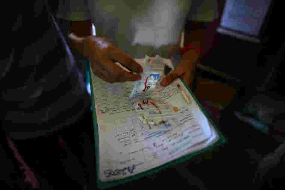 Susan Lake, a nurse for Doctors Without Borders, goes over the list of pills for one of her patients at the clinic in Dareta. More than 400 kids have already died from lead poisoning, while thousands of others are stunted physically and mentally.
