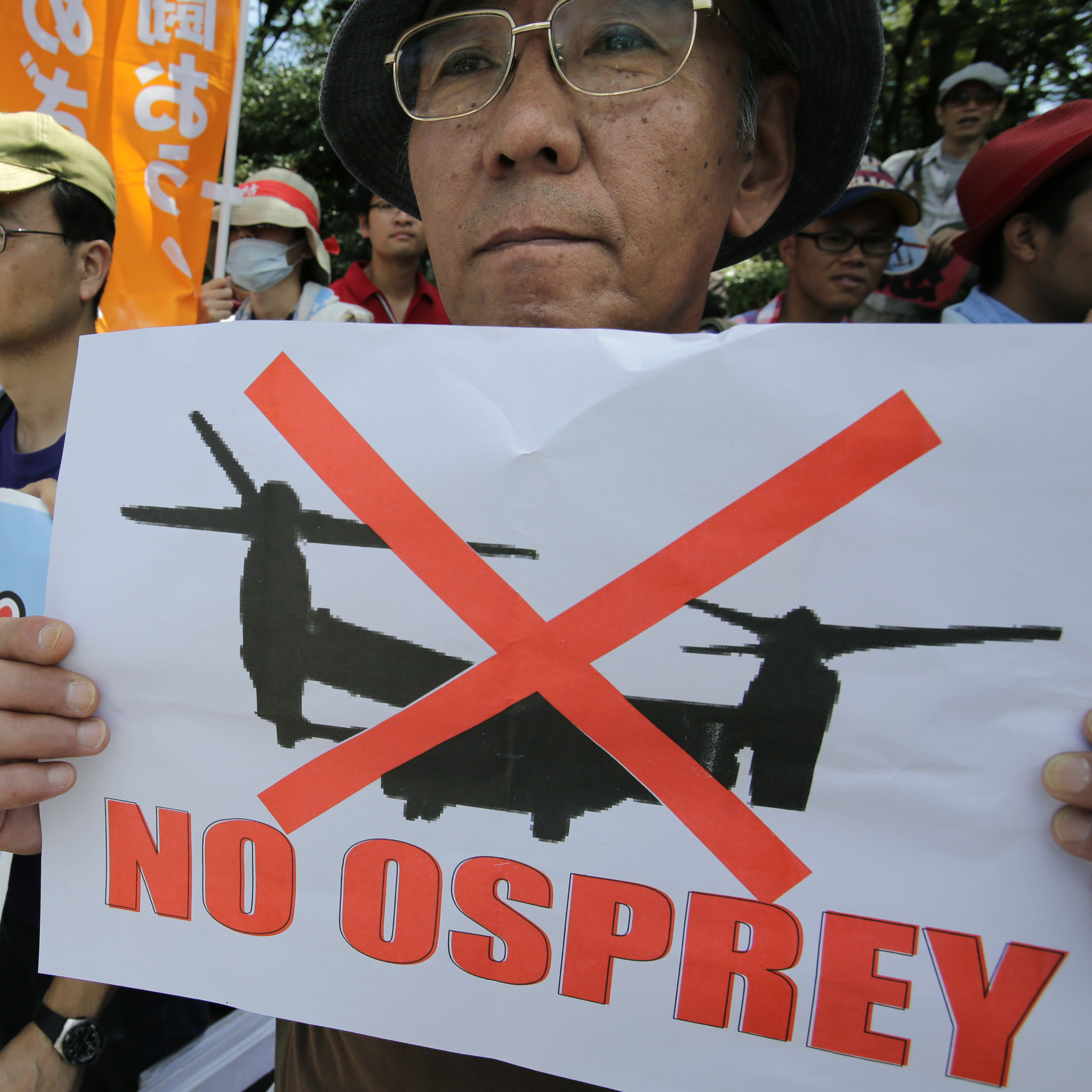 Demonstrators hold placards during a Sept. 9 rally outside the National Diet in Tokyo against the plan to deploy U.S. Osprey aircraft on Okinawa.