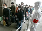 A railway worker wearing protective clothing to ward off the SARS virus controls a line of travelers as they wait to enter Beijing's West Railway Station Tuesday in 2003. A railway worker wearing protective clothing to ward off the SARS virus controls a line of travelers as they wait to enter Beijing's West Railway Station Tuesday in 2003.