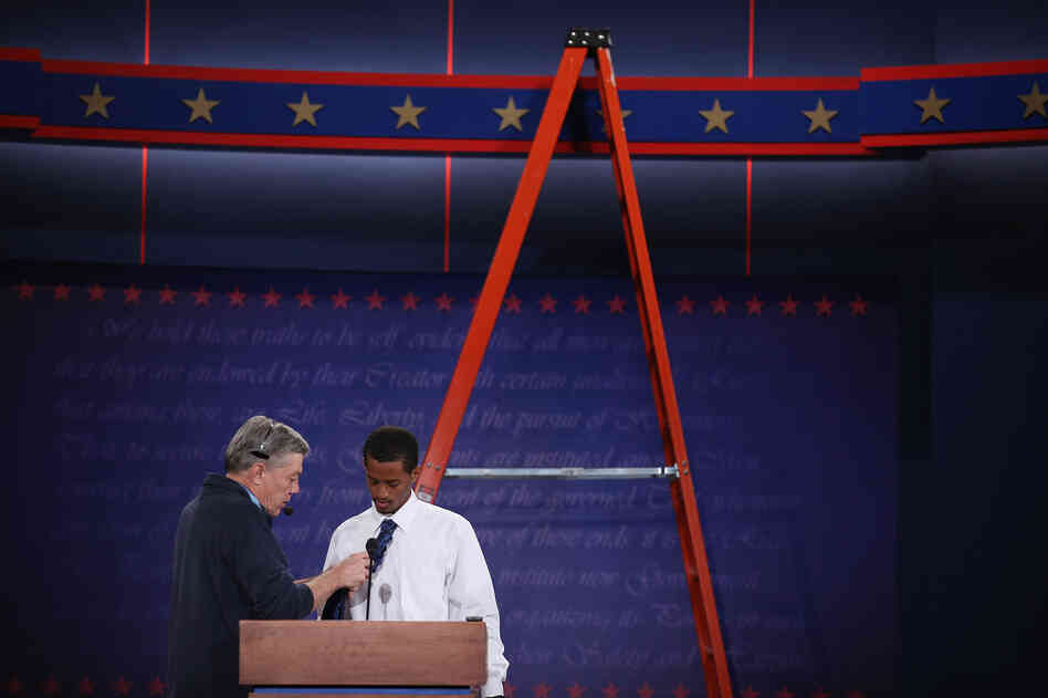 University student Dia Mohamed gets a wireless microphone put on his tie as he stands in for President Barack Obama during rehearsal for the first presidential debate in the Ritchie Center at the University of Denver on Tuesday.