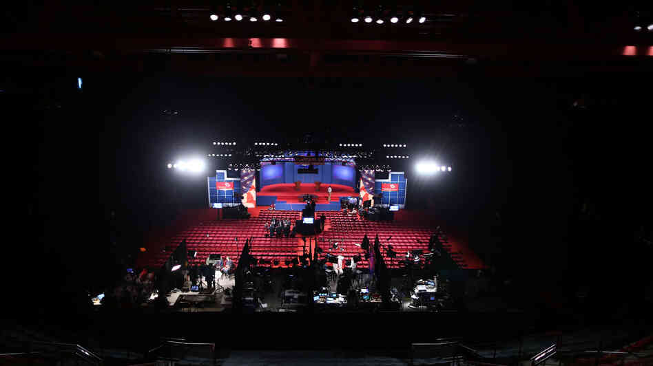 Workers prepare Wednesday for the presidential debate at the University of Denver. Experts differ over whether even a televised debate is a good forum for sharing very specific details about policy proposals.