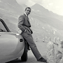 Sean Connery relaxes on the bumper of his Aston Martin DB5 during the filming of location scenes for Goldfinger in the Swiss Alps in 1964.