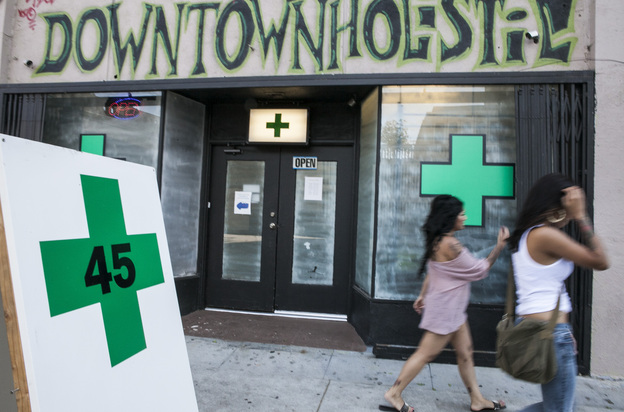 Pedestrians pass a medical marijuana dispensary in the Echo Park area of Los Angeles on July 24, 2012.
