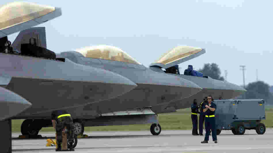 Air Force F-22 Raptors, made by Lockheed Martin, are prepared for flight operations at Langley Air Force Base. Despite the looming defense spending cuts that would go into effect in January if Congress does not pass a deficit reduction plan, Lockheed Martin and other defense contractors announced this week they would not issue layoff notices.