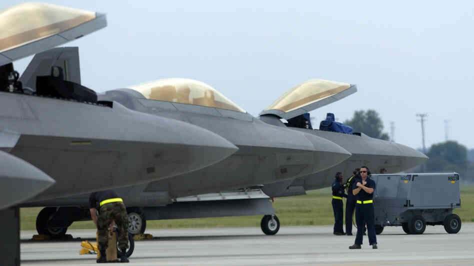 Air Force F-22 Raptors, made by Lockheed Martin, are prepared for flight operations at Langley Air Force Base. Despite the looming defense spending cuts that would go into effect in January if Congress does not pass a deficit reduction plan, Lockheed Martin and other defense contractors announced this week they would not issue layoff notices.