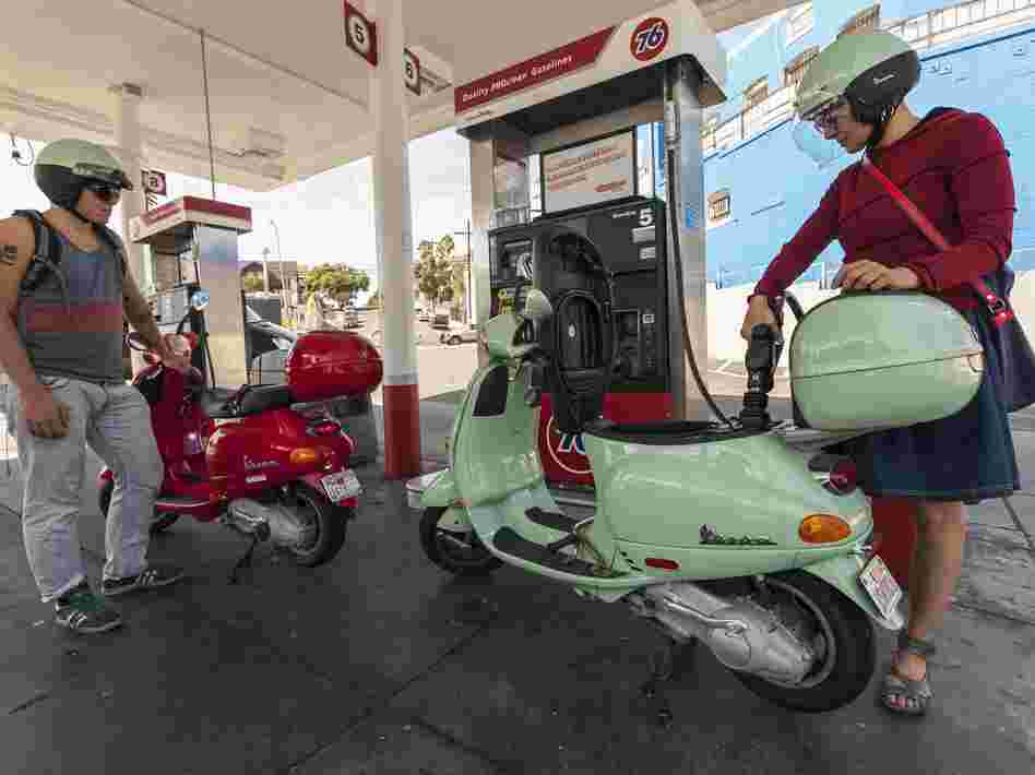 Motorcyclists Hanna Gilan, right, and her son Chaim Gilan fill up their Vespa scooters with less than two gallons at a gas station in the Echo Park district of Los Angeles on Oct. 4, 2012.