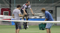 Todd Reichert pedals Atlas into the air, as Cameron Robertson (left) and team member Calvin Moes watch from the ground.