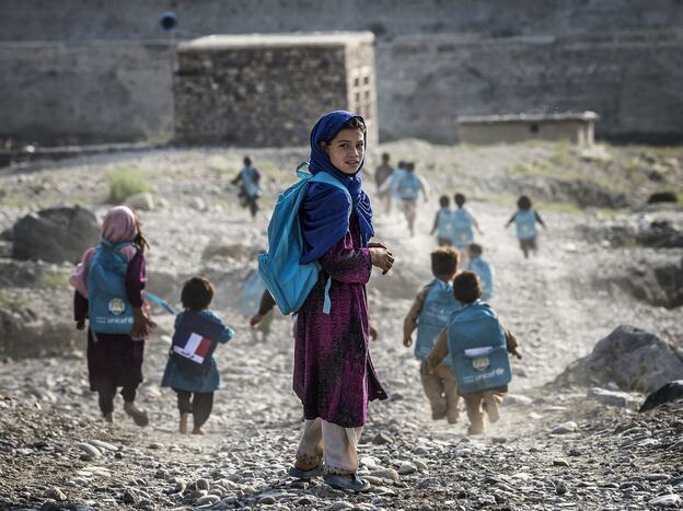 Afghan children run to school on Sept. 24. Whoever takes over as the next U.S. president will have to determine how many troops will remain after the December 2014 deadline to help with long-term security.